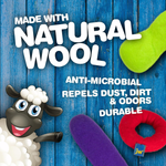 Sheep-shaped toy with text about natural wool on a blue wooden background