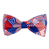 A patriotic bow tie featuring a patchwork design of American flag patterns, including stars and stripes, on a solid white background.