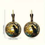 Pair of earrings with cat silhouette design against a moonlit sky, with measurements on a white background.