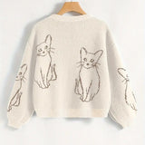 Beige sweater with cat illustrations on a hanger against a white background