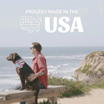 Person with a dog on a wooden bench by the ocean with 'Proudly Made in the USA' text overlay.