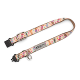 A pet collar with a pastel multicolor pattern of ice cream cones, stars, and stripes on a cream background, featuring a silver metal bell and black plastic hardware.