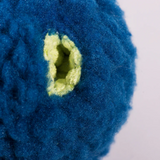 Close-up of a blue textured object with a green center on a white background