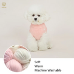 Dog wearing a pink sweater with yarn balls and text about softness, warmth, and machine washability.