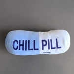 Squeezable pillow with 'CHILL PILL' text on a gray background