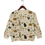 Beige sweater with animal pattern on a hanger against a white background