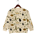 Beige sweater with animal pattern on a hanger against a white background