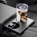 A white insulated tumbler with a clear lid and straw, printed with a dog portrait, resting in a car seat cup holder attached to the center console.