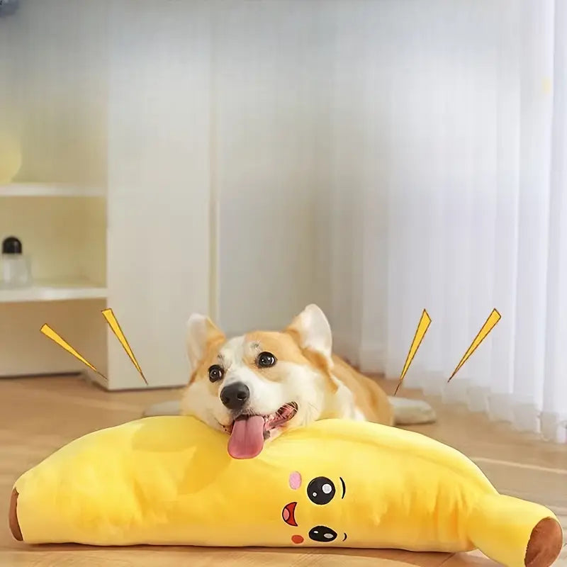 Dog lying on a banana-shaped pillow with a smiley face in a room.