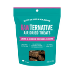 A teal stand-up pouch of RAWTernative Air Dried Treats for dogs, featuring a Lamb & Green Mussel Recipe. The packaging has pink and white text and a clear window at the bottom showing the brown air-dried treats inside.