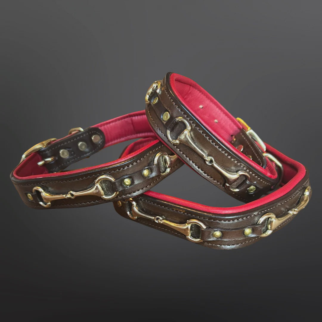 Two brown leather collars with brass hardware and a vibrant pink lining, arranged on a dark gray gradient background.