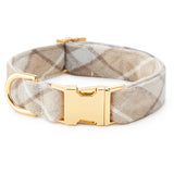 A dog collar with a beige and white argyle patterned fabric strap and a polished gold-tone metal buckle and D-ring, shown on a plain white background.
