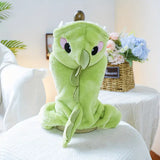 Green plush toy with owl design on a white surface