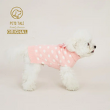 Small white dog wearing a pink polka dot sweater on a light gray background with 'Pets Tale' branding.