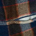 Close-up of a textured fabric with a checkered pattern featuring blue, brown, and orange colors.