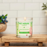 Pet House Candle on a wooden stand with a white tiled wall and decorative items in the background