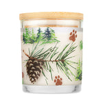 Candle with a wooden lid featuring pine branches, pinecones, and paw prints on a white background.