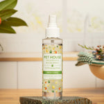 Pet House Fresh Citrus room spray bottle on a wooden surface with a blurred background