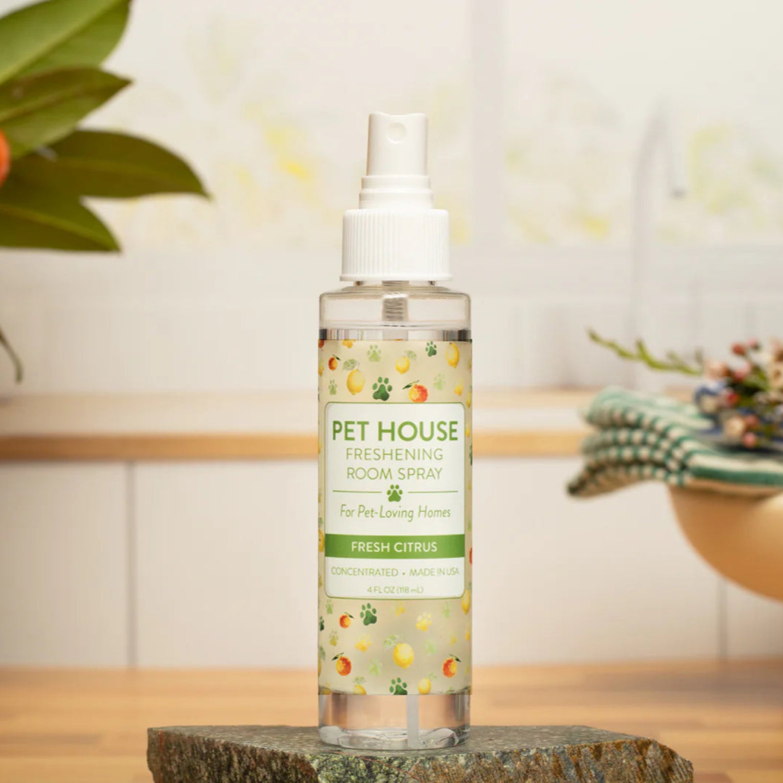 Pet House Fresh Citrus room spray bottle on a wooden surface with a blurred background
