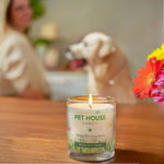 Pet House Candle on a table with a dog and person in the background