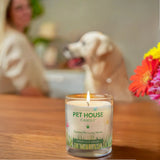 Pet House Candle on a table with a dog and person in the background
