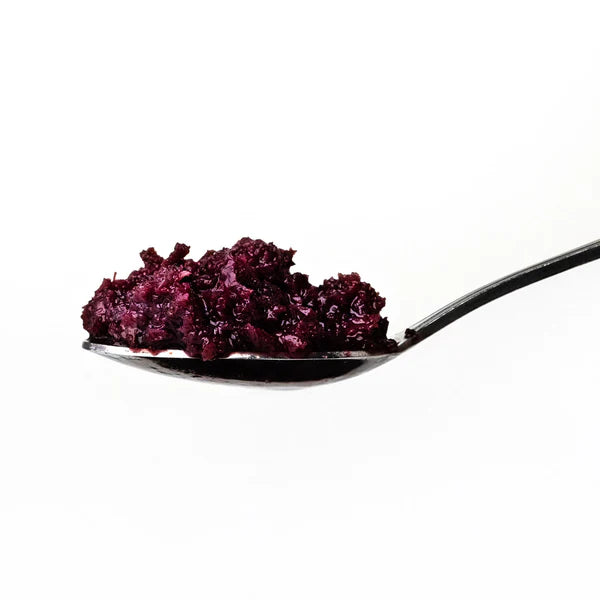 Spoon with purple substance on a white background