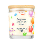 Candle with colorful paw prints and balloons design, featuring text 'The greatest birthday gift is love.' by Pet House.