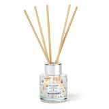 Reed diffuser with wooden sticks in a clear container on a white background
