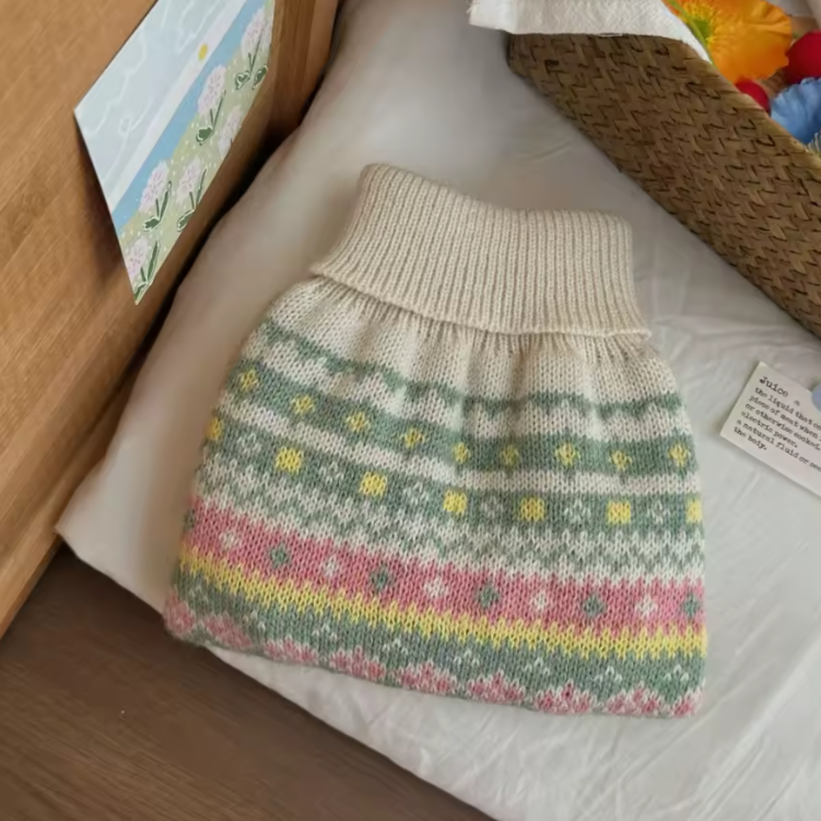 Knitted pet sweater with colorful pattern on a white surface