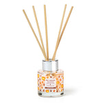 Reed diffuser with wooden sticks and a clear bottle on a white background