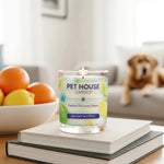 Pet House Candle on books with a dog and fruit in the background