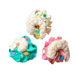 Three colorful donut-shaped treats with white filling on a white background