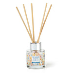Reed diffuser with wooden sticks in a glass container on a white background