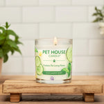 Pet House Candle on a wooden stand with plants and flowers in the background