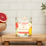 Pet House Candle on a wooden stand with fruits and flowers in the background