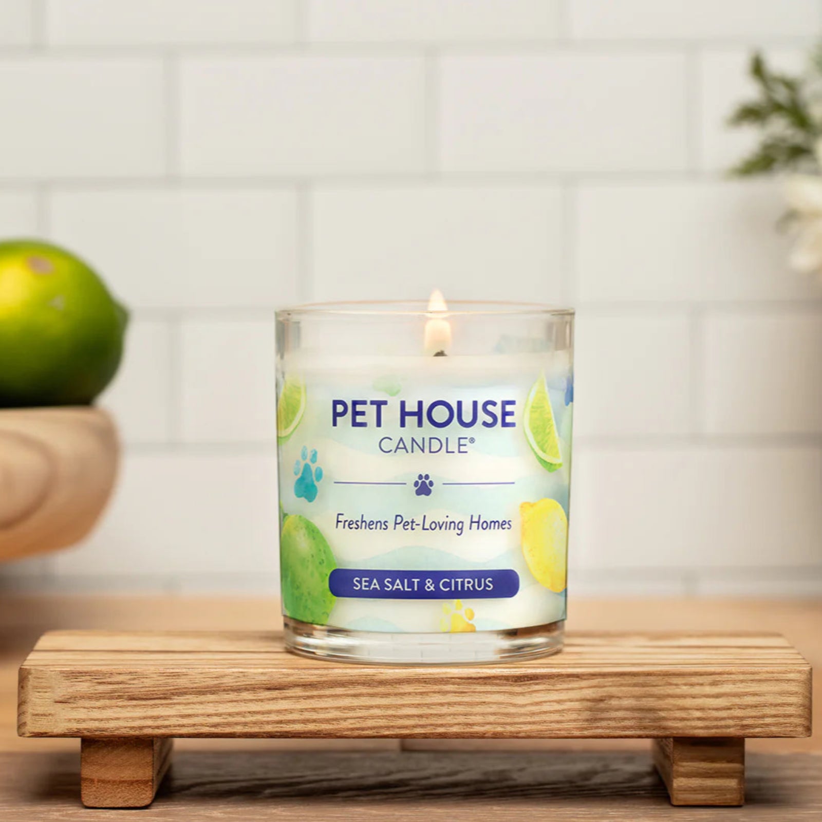 Pet House Candle on a wooden stand with lemons and limes in the background