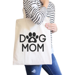 Person holding a tote bag with 'Dog Mom' text and paw print design.