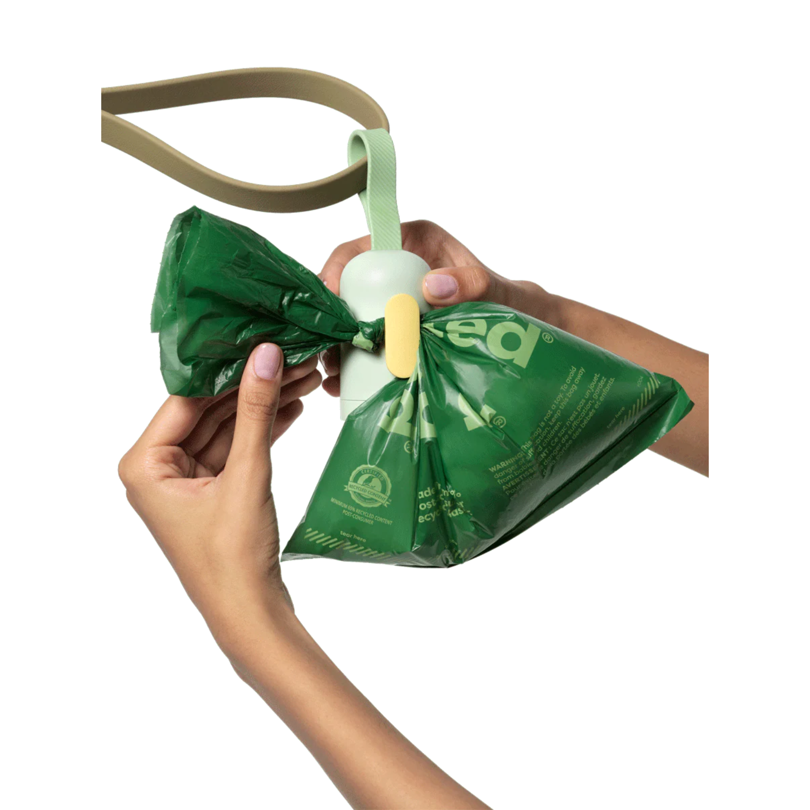 Green plastic bag with a white handle held by a person on a white background