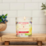 Pet House Candle on a wooden stand with flowers and a bowl in the background