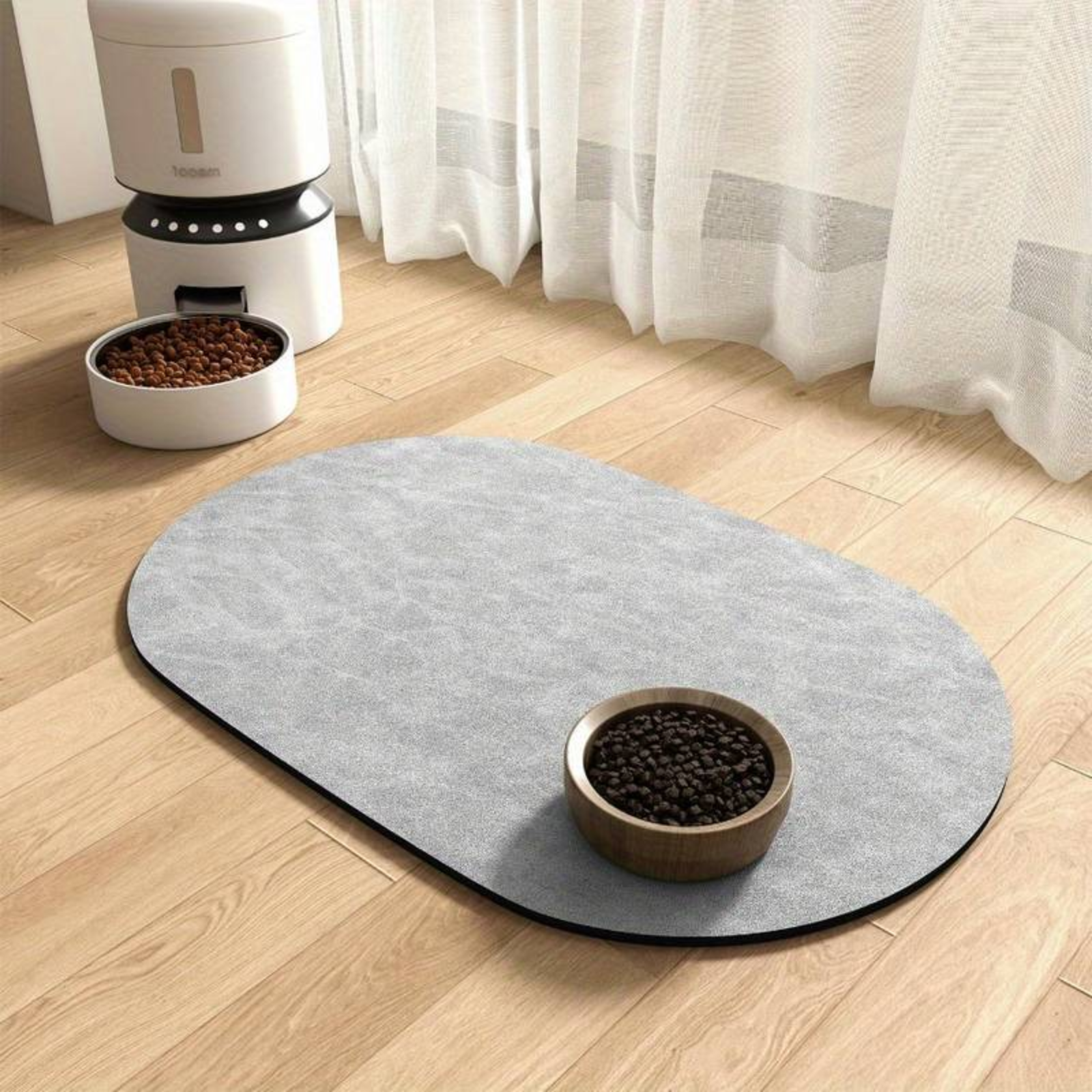 Pet food bowl on a light gray mat with a white curtain in the background