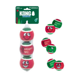 Kong Grinz 'Naughty Nice' dog toy set, featuring a mesh bag of three red and green tennis ball-shaped toys with cartoon faces, shown next to three loose toys on a white background.