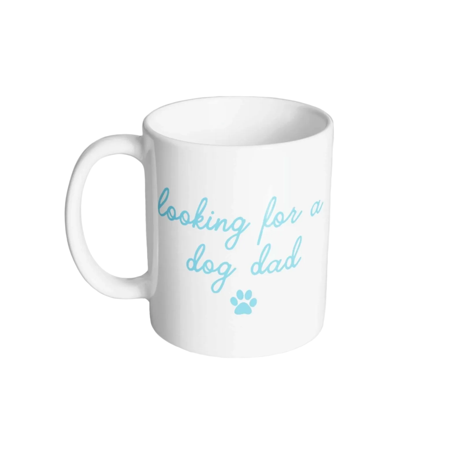 A white ceramic coffee mug with the text 'looking for a dog dad' and a small paw print printed in light blue, shown on a neutral light gray background.