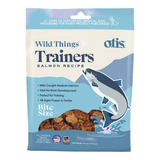 A package of Otis Wild Things Trainers Salmon Recipe dog treats, featuring a blue and white bag with an illustration of a salmon jumping out of water and a photo of the brown bite-size treats.