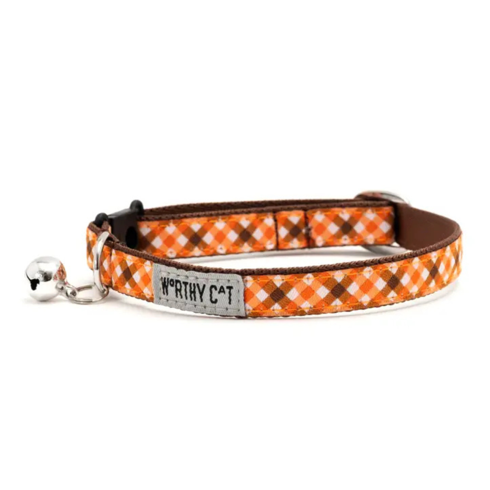 An orange and brown plaid cat collar with a silver metal bell and a central silver brand tag that reads 'WORTHY CAT'.