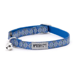 A blue patterned cat collar with a silver metal bell and a central fabric label that reads 'WORTHY CAT'.