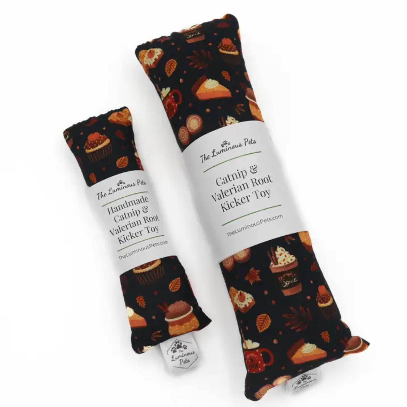 Two fabric catnip root kicker toys by The Luminous Pets, one small and one large, both featuring a dark background with a pattern of cupcakes, coffee cups, and autumn leaves, wrapped in white paper labels.