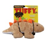 A Tuffy brand plush dinosaur dog toy in tan with orange spikes and a black harness, shown in front of its yellow retail packaging card.
