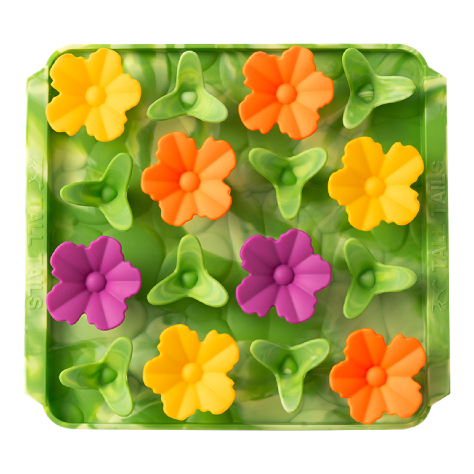 Colorful flower-shaped objects in a green mold on a white background