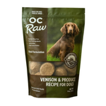 A 14 oz bag of OC Raw Venison & Produce Recipe for Dogs freeze dried treats, featuring a dark green and brown package with a photo of a brown dog and a clear window showing the round treats inside.