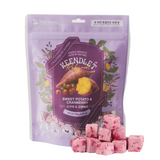 A purple stand-up pouch of Keendle Naturals Sweet Potato & Cranberry pet treats, shown with several pink cube-shaped treats arranged in front on a white background.